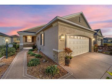 Well-maintained house with a two-car garage and landscaped walkway at 9872 Sw 99Th Loop, Ocala, FL 34481