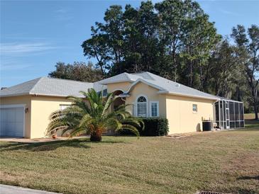 Tan one-story house with grey roof, palm tree, and screened enclosure at 11105 Sw 69Th Cir, Ocala, FL 34476