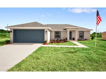 Single-story home with a two-car garage and landscaped lawn at 18 Juniper Trl, Ocala, FL 34480