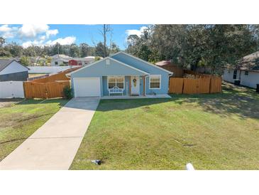 Cute light blue house with a fenced yard and driveway at 21654 Sw Honeysuckle St, Dunnellon, FL 34431