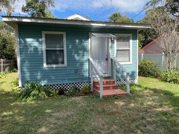 Charming light blue house with a well-maintained lawn and landscaping at 2211 Sw 1St St, Ocala, FL 34475