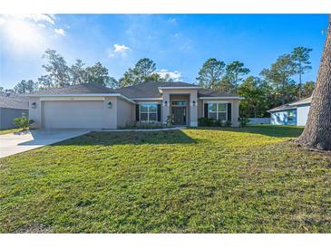 Single-story house with a two-car garage and well-maintained lawn at 3914 Ne 58Th Cir, Silver Springs, FL 34488