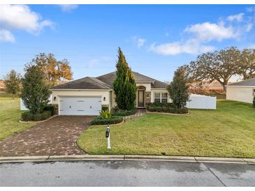 Single-story house with brick driveway, two-car garage, and landscaped lawn at 4314 Sw 65Th Pl, Ocala, FL 34474