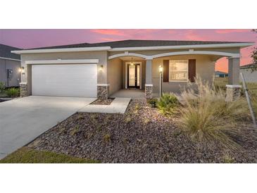 Single-story home with white garage door and landscaped yard at 8761 Sw 79Th Loop, Ocala, FL 34481