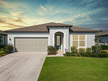 One-story home with gray siding, attached garage, and landscaped lawn at 9474 Sw 52Nd Loop, Ocala, FL 34481