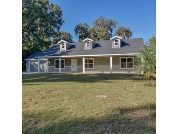 Single-story home with gray siding, covered porch, and a well-maintained lawn at 000 Ne 30Th Ct, Reddick, FL 32686