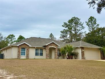 One-story house with stone accents and a two-car garage at 1060 Sw Big Tree Rd, Dunnellon, FL 34431