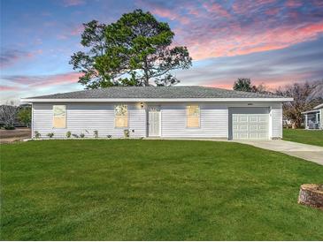 Newly constructed single-story home with a white exterior and a well-manicured lawn at 10856 Sw 79Th Ave, Ocala, FL 34476