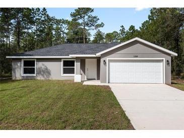 Newly constructed home with a gray exterior, two-car garage, and spacious lawn at 1280 Nw Redwood Dr, Dunnellon, FL 34431