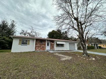 Brick and white ranch home with a carport and mature trees at 14419 Sw 43Rd Court Rd, Ocala, FL 34473