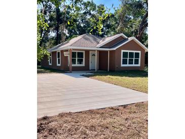 Charming single-story home with a well-manicured lawn and a spacious driveway at 2998 Se 140Th Ln, Summerfield, FL 34491
