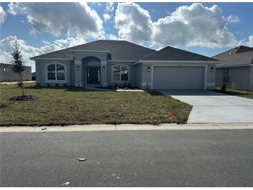 New gray house with two-car garage and landscaped lawn at 5110 Sw 92Nd St, Ocala, FL 34476