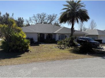 Single-story home with gray roof and landscaped yard at 5824 Sw 100Th Ln, Ocala, FL 34476