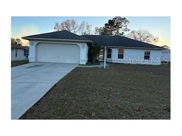 Single-story home with attached garage and grassy front yard at 8512 Sw 136Th Pl, Ocala, FL 34473