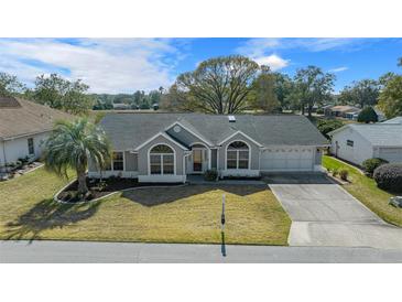 Charming home with a well-maintained lawn, complemented by a picturesque palm tree in a tranquil neighborhood setting at 8822 Sw 108Th St, Ocala, FL 34481