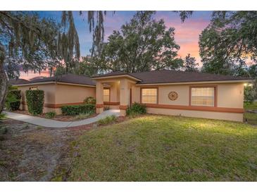 House exterior view at dusk, showing a walkway and landscaping at 10090 Sw 78Th Ct, Ocala, FL 34476