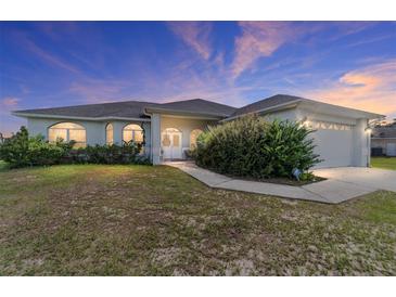 One-story house with attached garage, lush lawn, and walkway at 4864 Sw 103Rd Street Rd, Ocala, FL 34476