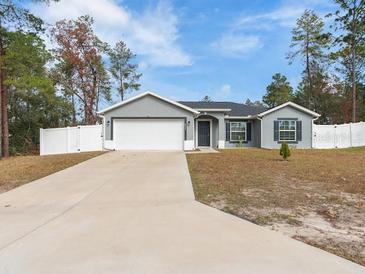 Gray house with a two-car garage and a long driveway at 4947 Sw 166Th Loop, Ocala, FL 34473