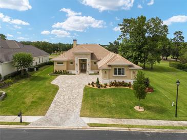 Luxury home with a large paved driveway and beautifully landscaped lawn at 7549 Nw 33Rd Pl, Ocala, FL 34482