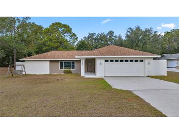 Single-story home with attached garage and landscaped yard at 19699 Sw 88Th Place Rd, Dunnellon, FL 34432