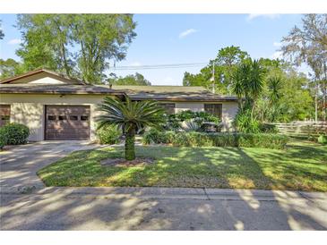 Tan house with brown garage door and nicely landscaped yard at 3856 Ne 19Th Street Cir, Ocala, FL 34470