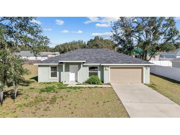 Charming single-story home featuring an attached two-car garage and well-maintained lawn at 4069 Sw 130Th Pl, Ocala, FL 34473