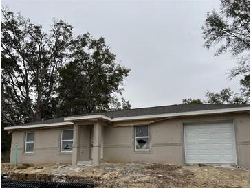 Newly constructed single-story home with a covered entryway and attached garage at 4481 Sw Clearwater Ct, Dunnellon, FL 34431