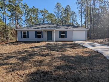 Newly constructed home with a grassy yard and driveway at 963 Sw Temple Heights Ct, Dunnellon, FL 34431