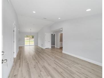 Bright living room boasts hardwood floors, recessed lighting, and sliding glass doors to the backyard at 2675 Sw 158Th Ct, Ocala, FL 34481