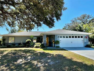 Charming single-story home featuring a well-manicured lawn and a two-car garage at 6082 Sw 104Th St, Ocala, FL 34476