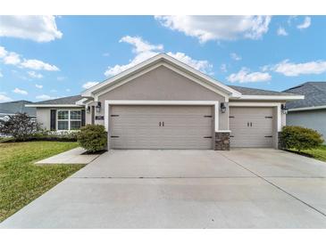 House exterior featuring a two-car garage and well-manicured lawn at 8405 Sw 59Th Ter, Ocala, FL 34476