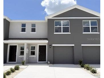 Contemporary townhome featuring a two-car garage, neutral paint scheme and a concrete driveway at 8410 Gower Trl, Wildwood, FL 34785