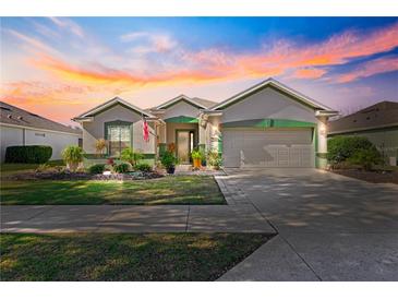 One-story house with landscaped yard, two-car garage, and American flag at 9470 Sw 66Th Loop, Ocala, FL 34481