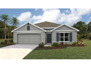 Single-story home with gray siding, two-car garage, and landscaped lawn at 10012 Se 161St Lane Rd, Summerfield, FL 34491