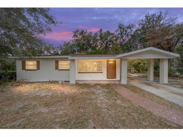 Inviting single-story home with a brick walkway and attached carport nestled amongst mature trees at 2501 Nw 20Th St, Ocala, FL 34475