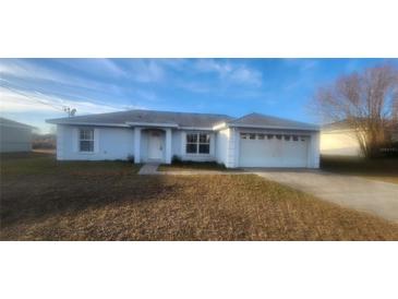 One-story home with attached garage and grassy yard at 28 Juniper Loop Ter, Ocala, FL 34480