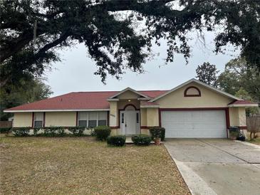 Ranch-style home with red roof, attached garage, and well-maintained landscaping at 5980 Se 4Th Pl, Ocala, FL 34472