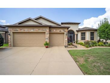 Two-story house with a three-car garage and landscaped lawn at 7646 Sw 100Th Ct, Ocala, FL 34481