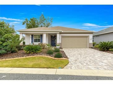 One-story home with landscaped yard, paver driveway, and two-car garage at 7977 Sw 85Th Loop, Ocala, FL 34476