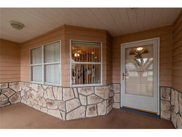 Inviting front porch featuring stone accents, and a clear view of the entrance at 9051 Sw 96Th Ln # B, Ocala, FL 34481