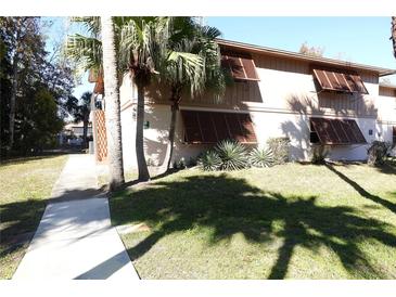 Building exterior with palm trees and walkway at 100 Sweetgum Woods Ct # 8C, Deltona, FL 32725