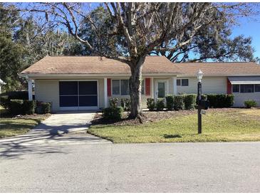 Tan one-story house with a garage and landscaped yard at 10829 Sw 83Rd Ave, Ocala, FL 34481