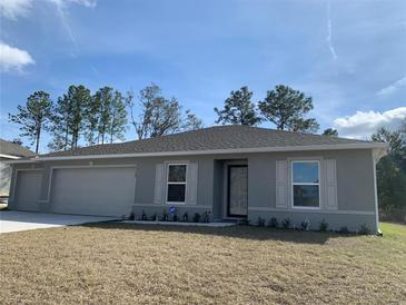 Gray house with a two-car garage and landscaping at 15155 Sw 52 Cir, Ocala, FL 34473