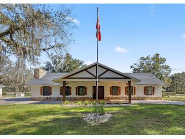 Ranch-style home with covered porch and landscaped yard at 15315 Nw 115Th Ct, Reddick, FL 32686