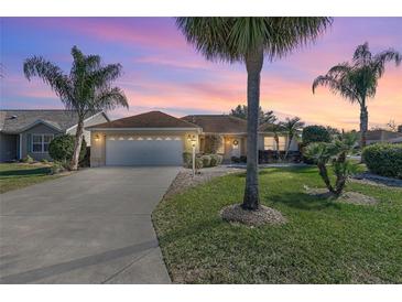 Charming single-story home with a two-car garage and landscaped lawn at 1982 Somerset Ave, The Villages, FL 32162