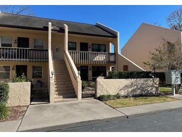 Two-story condo building with stairs and gated entry at 2418 Ne 7Th St # 9, Ocala, FL 34470