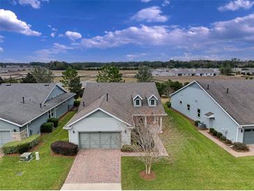 Exterior view of charming house with two-car garage and manicured lawn at 4775 Nw 35Th Lane Rd, Ocala, FL 34482