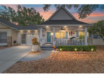 Brick home with covered porch, landscaped yard, and two-car garage at 8540 Sw 90Th Pl # B, Ocala, FL 34481