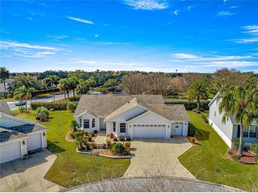 Charming home featuring a brick driveway, well-manicured landscaping and an attached two-car garage at 2630 Dunbar Ave, The Villages, FL 32162