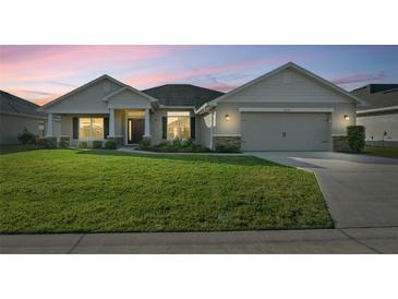 One-story home with stone accents, two-car garage, and manicured lawn at 5826 Sw 83Rd Ln, Ocala, FL 34476